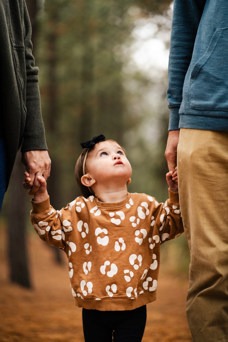 Young family walking hand in hand with their baby girl | Bundled, for parents by parents, gently-loved childrenswear bundles in Canada